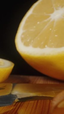 Limon ve zencefil dilimleri masaya saçılmış, bir tahta kaşık alıyorum ve her şeyin üzerine bal döküyorum. Dolly Slider aşırı yakın çekim. Dikey video Sosyal Ortamı