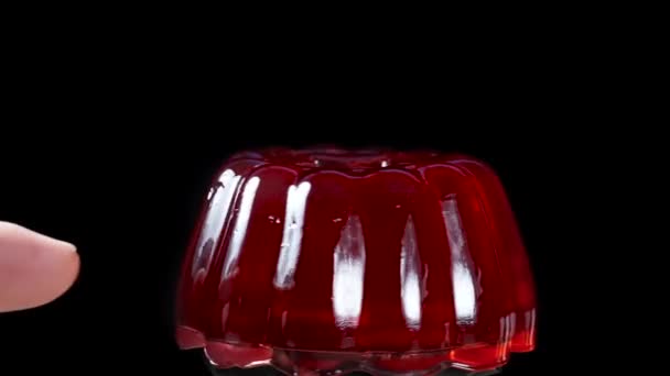 Red Jelly Rotates Close Black Background Touch Finger Sways Slow — Stock Video