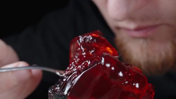 Red Jelly Περιστρέφεται Ένα Μικρό Τραπέζι Και Ένας Άντρας Τρώει — Αρχείο Βίντεο