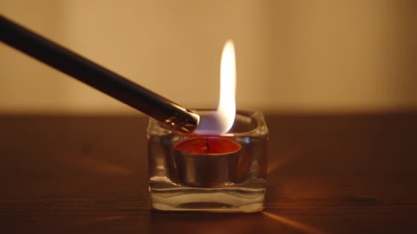 玻璃杯里的红色蜡烛 用一个长长的打火机点火 在一张木制桌子上 — 图库视频影像