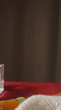 Papatya çayı koyuyorum ve naneli, limonlu ve zencefilli. Mumlar kırmızı bir masa örtüsüyle kaplı bir masanın üzerinde yakılır. Dolly Slider aşırı yakın çekim. Dikey video Sosyal Ortamı