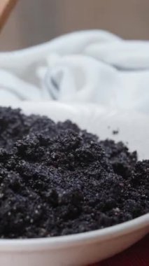 Tahta bir kaşıkla, bir tabak haşhaş tohumu dolduruyorum çörekler için, dikey video sosyal medya