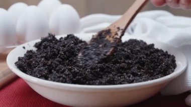 Tahta bir kaşıkla, haşhaş dolgusunu, masada yumurtaları ve kırmızı masa örtüsüyle beyaz örtüyü karıştırıyorum. Dolly kaydırıcı