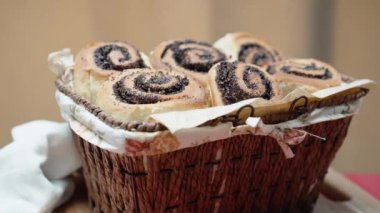 Slaytlı bir hasır sepet içinde haşhaş tohumları, tahta bir masa örtüsü ve kırmızı bir masa örtüsü olan çöreklerle doldurulur. Dolly kaydırıcı.