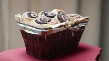 Hasır sepet tamamen haşhaş tohumlu çöreklerle dolu, kırmızı bir masa örtüsü üzerinde dönüyor..