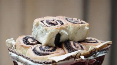 Hasır sepet ağzına kadar haşhaşlı çörekle dolu. Titreyen bir mumun arka planında dönüş. Yakın plan.