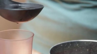 Paskalya için yumurta boyayıp pişiriyoruz. Kaskade 'den gelen kırmızı boyayla bardağa yumurta döküyorum. yakın plan.