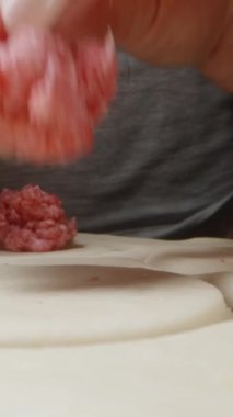 Hamur köfteleri için kıyma parçalarını hamurun üzerine yaydım. Dolly Slider aşırı yakın çekim. Dikey video Sosyal Ortamı
