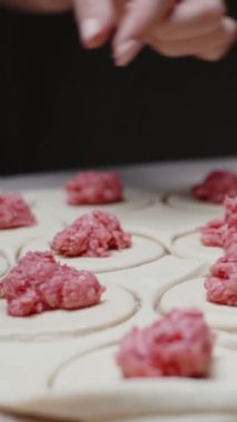 Hamur rulosunun üzerine ev yapımı kıyma koydum ve yuvarlak parçalara ayırdım. Dikey video Sosyal Ortamı