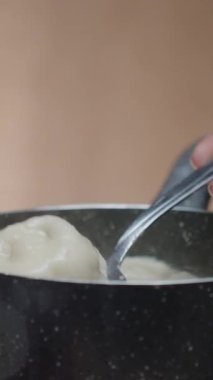 Sıcak hamur köftelerini beyaz tabağa koydum. Buhar onlardan geliyor. yakın çekim, yavaş çekim dikey video sosyal medya
