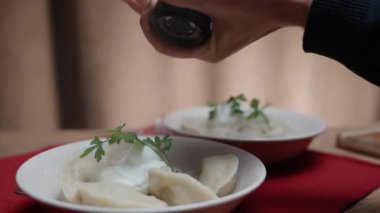 Ekşi kremalı ve biberli ev yapımı taze haşlanmış hamur tatlısı. yavaş çekim.