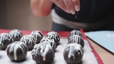 Çikolata toplarına hindistan cevizi talaşı serpin. Yavaş çekim yakın çekim