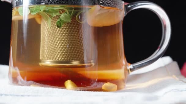 在茶壶里煮茶 里面有一个金属筛子 柠檬片和薄荷叶漂浮着 滑行了 — 图库视频影像