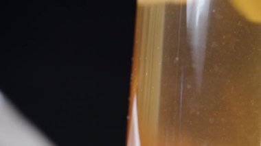 Çay cam çaydanlıkta demlenir, çay ve limon parçacıkları tepeye yükselir. Nane yaprakları, Dolly sürgülü aşırı yakın çekim.