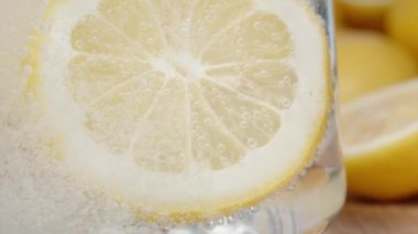 Limonata bardağında bir dilim limon. Baloncuklara yakın çekim. Yavaş çekim.