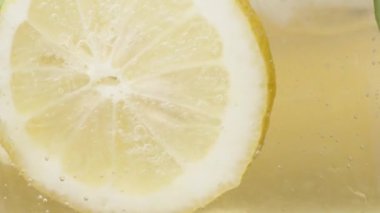 Limonata ve buzu karıştırıyorum, limon ve nane karışımı, yavaş, makro.