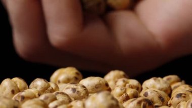 Ellerimden bir avuç kızarmış nohutu döküyorum. Yavaş çekim.