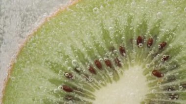 Gazozdaki kivilerden kabarcıklar yavaşça yükseliyor. Macro, ağır çekim. Pano