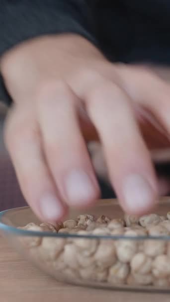男人拿起手中的鹰嘴豆 把它们倒入盘子里 垂直视频社交媒体 — 图库视频影像