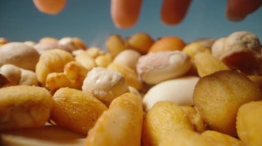 Bir kadının eli masaya bir avuç fındık koyar. Yakın çekim, ağır çekim..