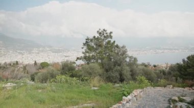 Dağdan deniz kentine bak. Güneşli ve bulutlu bir gün.