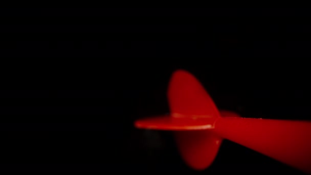 Красный Дротик Дартс Вращается Летает Черном Фоне Медленное Движение Макросов — стоковое видео