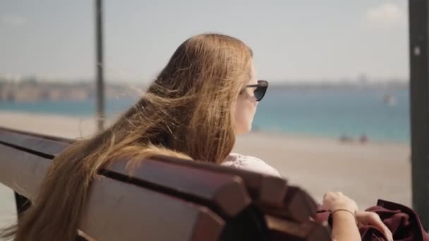 Eine Junge Frau Sitzt Auf Einer Bank Meer Und Blickt — Stockvideo