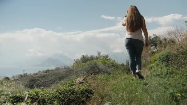 Μια Νεαρή Γυναίκα Περπατά Ένα Μονοπάτι Ψηλά Στα Βουνά Δίπλα — Αρχείο Βίντεο