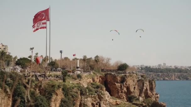 Menschen Mit Einem Gleitschirm Fliegen Über Eine Klippe Meer Flagge — Stockvideo