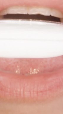 Bir kadın ölçü kaşığına ilaç dolduruyor, makro dikey video..