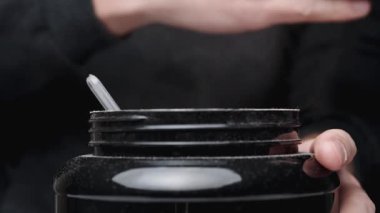 Siyah bir Spor Kutusu Beslenme. Protein tozu yükselir ve onu ellerimle şişiririm..