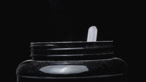 Eiweißpulverpartikel Fliegen Durch Die Luft Sportnahrungsdose Isoliert Auf Schwarzem Hintergrund — Stockvideo
