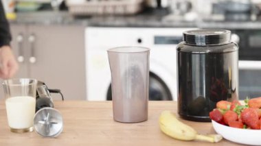 Protein spor kokteyli yapmak için gerekli malzemeler. Kavanozu açıp proteini bardağa boşaltıyorum..