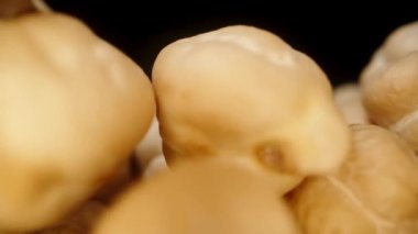 Kamera, siyah bir zemin üzerinde bir makro kaydırıcı olan kurumuş nohut yığınının içinden geçiyor. Yavaş çekim