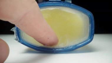 Parmağımı bir vazelin kavanozunda yağlıyorum, yakın plan..
