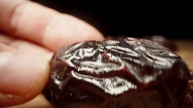 Kameranın önünde yakın planda kurutulmuş tarihlere bakıyorum..