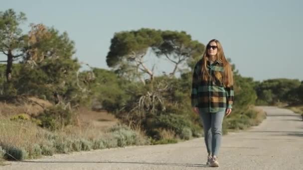 Una Joven Camina Por Una Carretera Abandonada Través Del Bosque — Vídeos de Stock