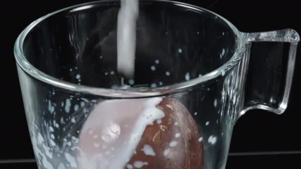 チョコレートボールに熱いミルクをマグカップに入れて溶かします スプラッシュ クローズアップ — ストック動画