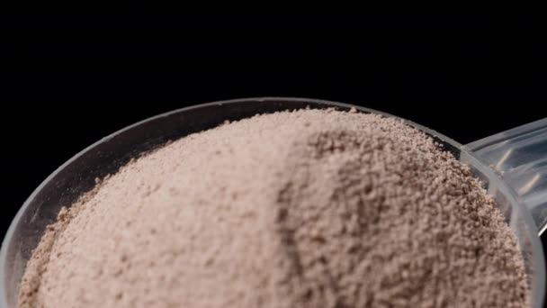 測定スプーンのタンパク質粉末 黒い背景で回転する ズーム — ストック動画