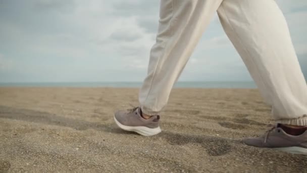 Ноги Фіолетових Кросівках Білі Штани Йдуть Піщаним Пляжем Уздовж Моря — стокове відео