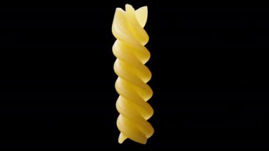 Yalnız bir fusilli makarna, siyah arka planda dönen bir spiral, yakın plan.