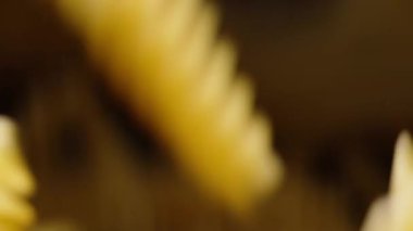 Fusilli makarna cam konteynerin tepesinden dibine düşer ve tüm alanı kaplar, süreci yavaşlatır.