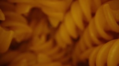 İçinde fusilli makarna olan kap, makarnadan fırlayan kamera ve masadan alınıyorlar. Dolly kaydırıcı aşırı yakın çekim.