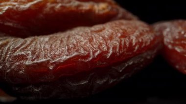 Siyah arka planda kurumuş kayısılar ve ayna görüntüsü. Dolly kaydırıcı aşırı yakın çekim.