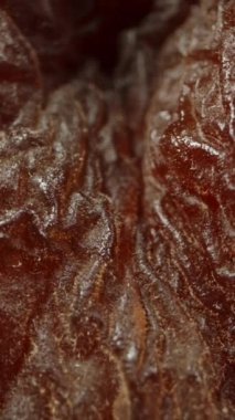 Siyah arka planda tek bir kurutulmuş kayısı, makro zoom. Dikey video.