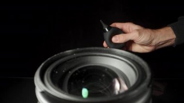 Siyah arka plandaki kamera için ön lens. Lastik Ampul Hava Pompası ile tozu üflüyor.
