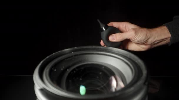 在黑色背景上的相机前置镜头 用橡皮灯泡气泵吹掉灰尘 — 图库视频影像