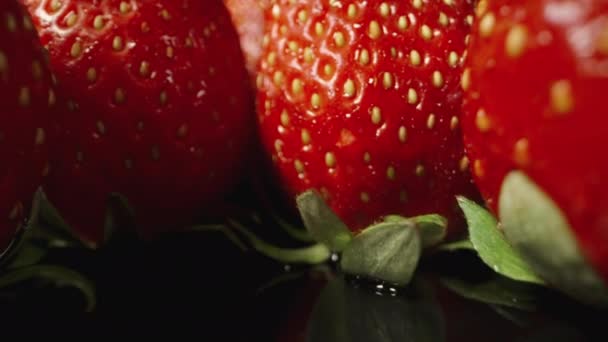 多汁的草莓整齐地摆放在一张黑色镜面桌子上 多利滑翔机极端特写 — 图库视频影像