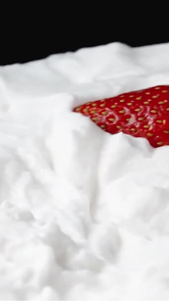 검은색 배경에 회전하는 휘핑크림 층으로 플레이트 슬로우 모션에서 딸기가 그것에 — 비디오