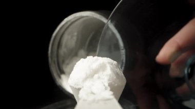 Kavanozdan bir kaşık beyaz toz alıp bir bardağa dolduruyorum. Çekim birinci şahısta yavaş çekimde olacak..